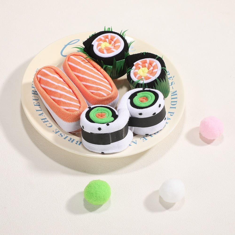 Lohen ja makin näköisiksi rullatut sushisukat lautasella